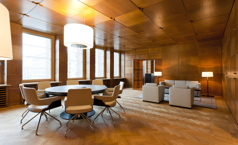 Der Raum Intermezzo mit rundem Tisch und hochwertigem Lounge-Mobiliar aus Leder