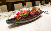 Blumendeko in einer Schale auf der gedeckten Tafel im Meetingraum Symphonie